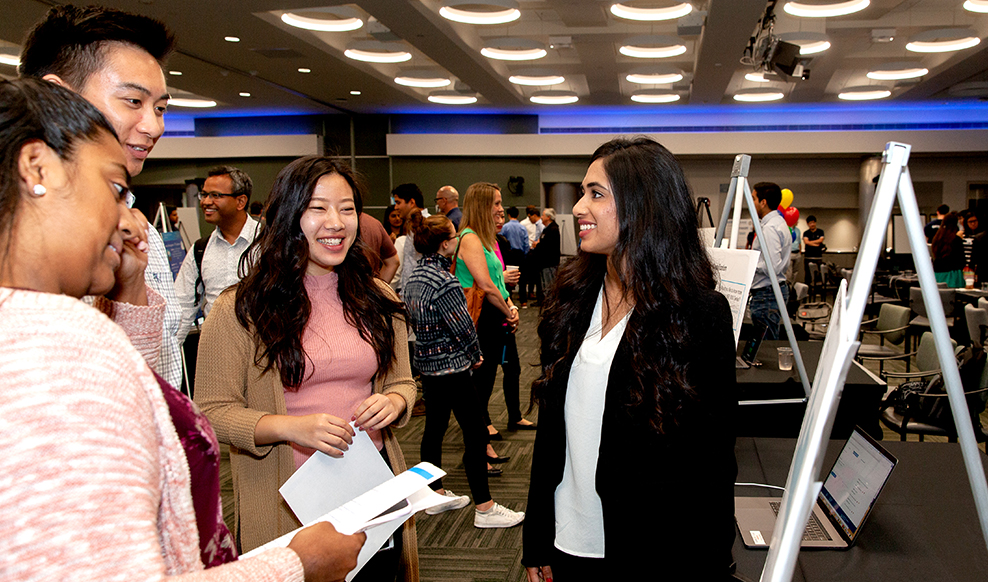 Female presenting to three other employees at a Cisco event