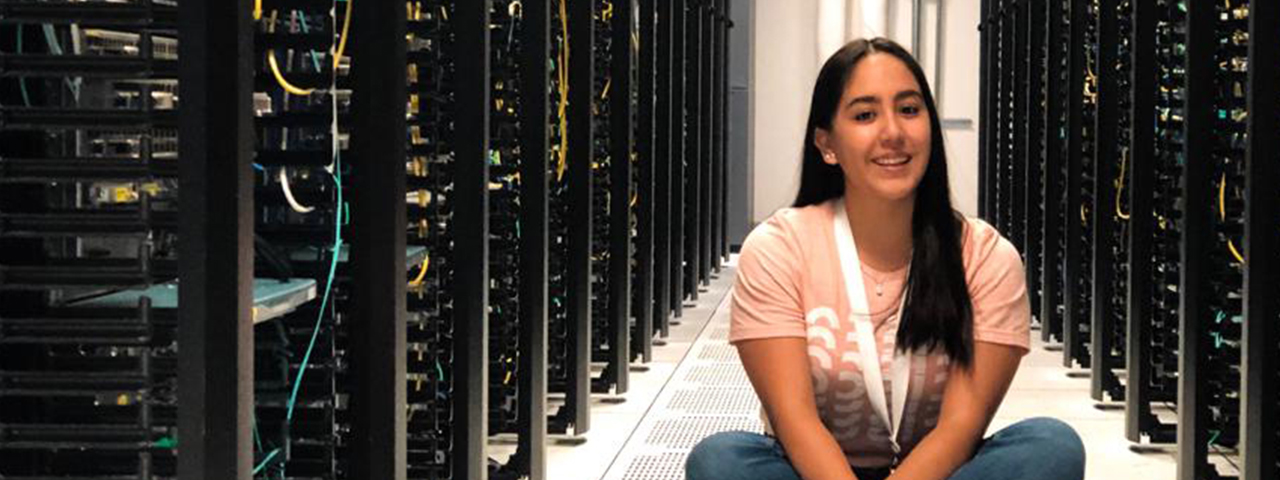 Person sitting in an aisle of Cisco hardware.