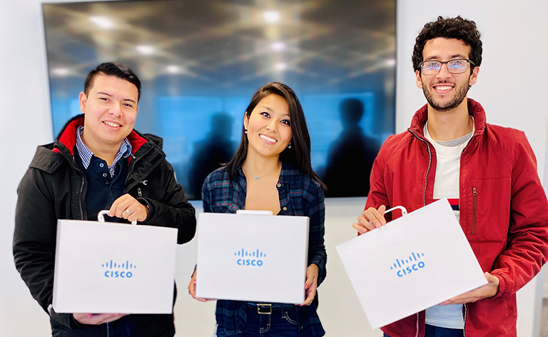 Three people stand together and smile while holding Cisco briefcases.