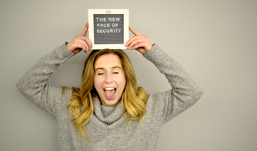 Person holding a sign that reads, 'The new face of security,' above their head.