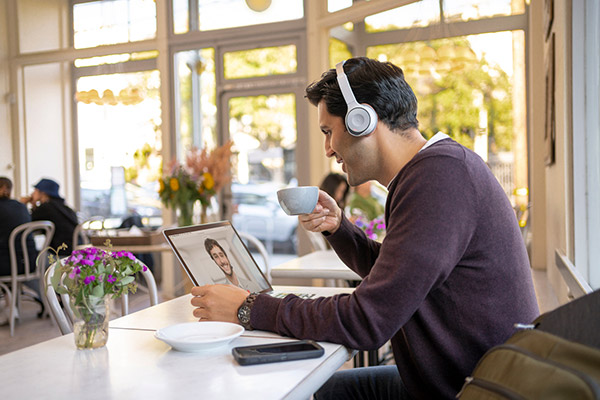 コーヒーショップで Cisco ヘッドセットを付けている男性