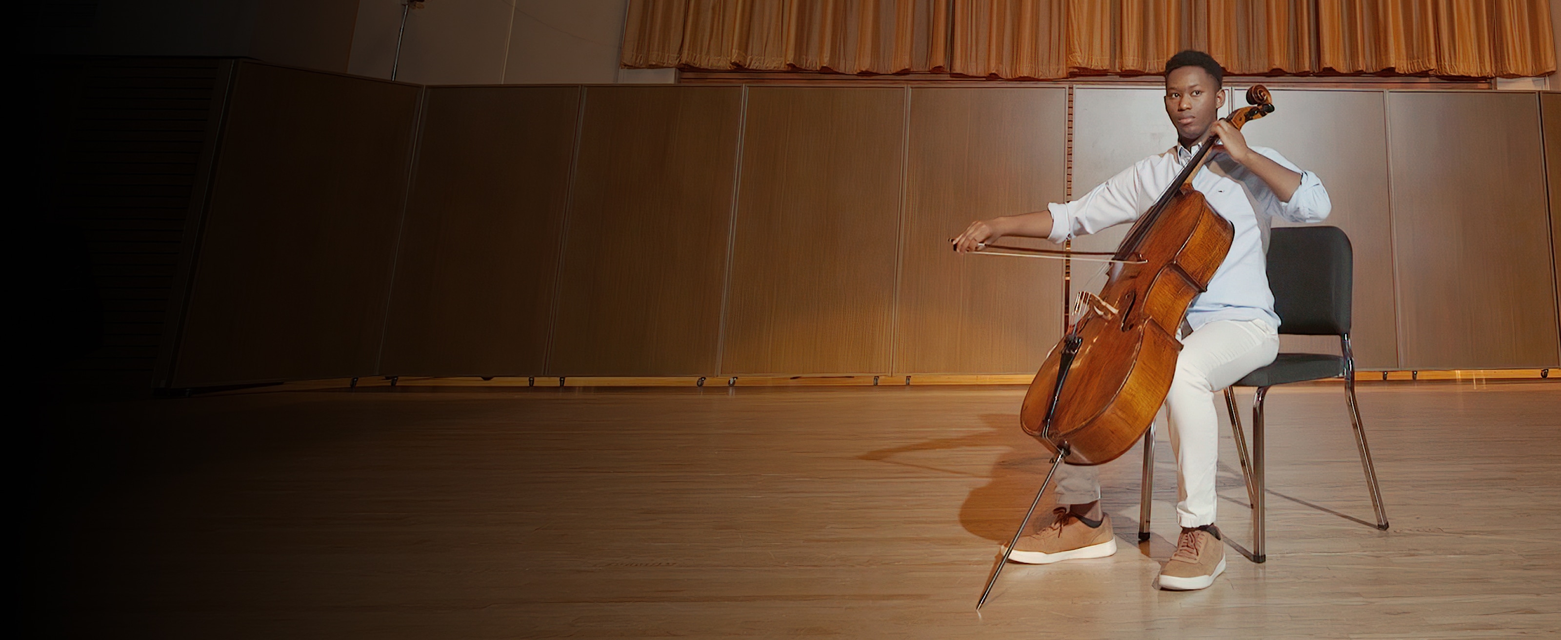 A person sitting, playing a cello