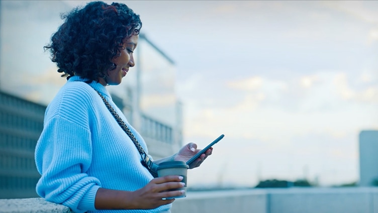 Woman outside building looking at iphone